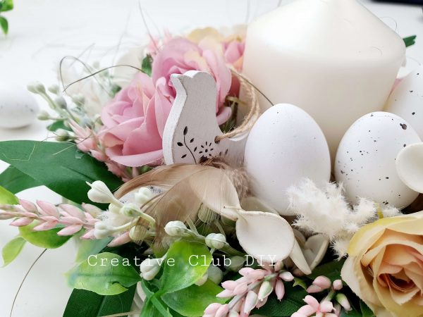 stroik wielkanocny z jajkami, świecą kwiatami i drewnianym ptaszkiem